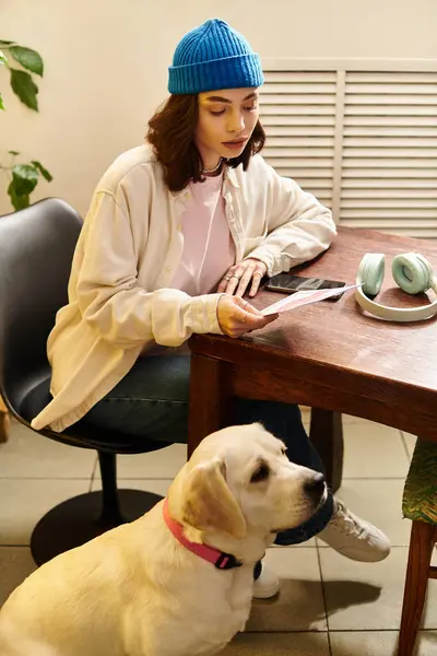 A young woman relaxes at a cafe, reading menu while her labrador sits close by, enjoying the atmosphere. — Stock Photo