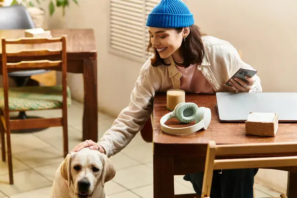 Young woman enjoys her time with a friendly labrador in a modern cafe atmosphere. — Stock Photo