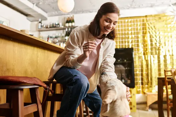 A young woman enjoys time with her labrador at a modern cafe designed for pets. — Stock Photo