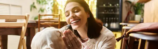 Smiling woman interacts lovingly with her labrador in a vibrant cafe, banner — Stock Photo