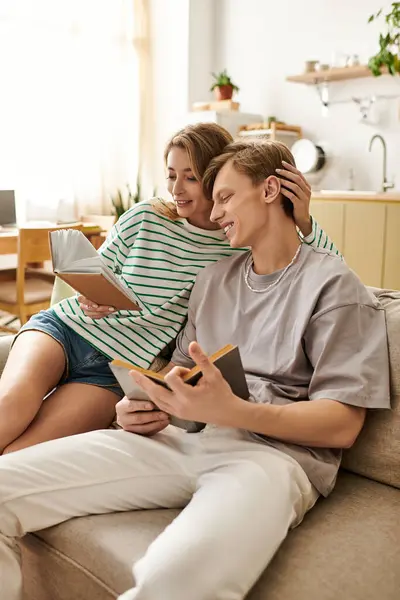 Couple relaxes on a cozy sofa, enjoying a warm reading experience among home decor. — Stock Photo