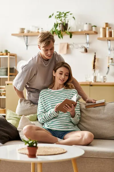 Loving couple relaxes in their stylish living room, sharing a tender moment while reading books. — Stock Photo