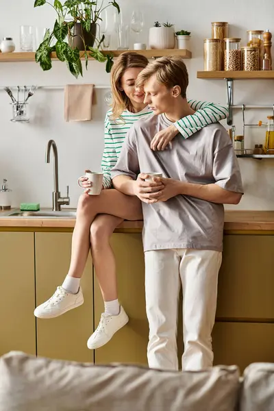 A young couple enjoys a cozy moment in their beautifully designed kitchen, radiating love and joy. — Stock Photo