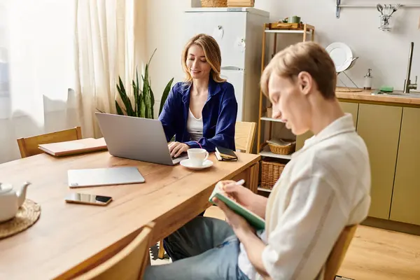 Loving couple shares a warm moment at home, balancing work and affection in a bright space. — Stock Photo