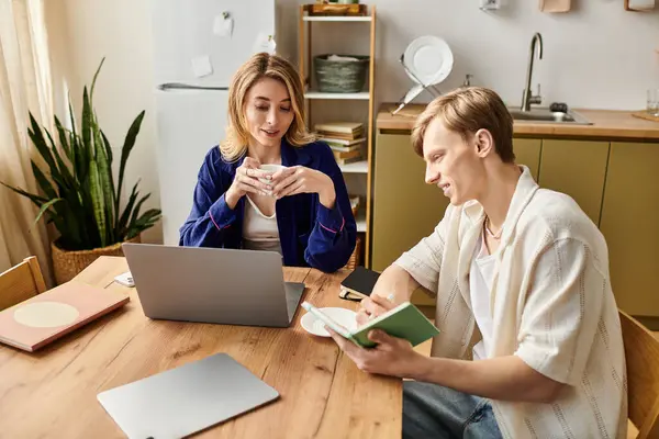 Couple engages in a cozy conversation while working on tasks at their modern home dining table. — Stock Photo