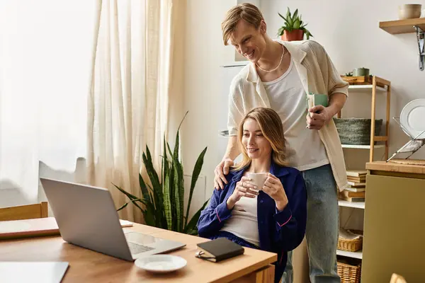 A young couple enjoys each others company at home, sipping drinks and sharing smiles. — Stock Photo