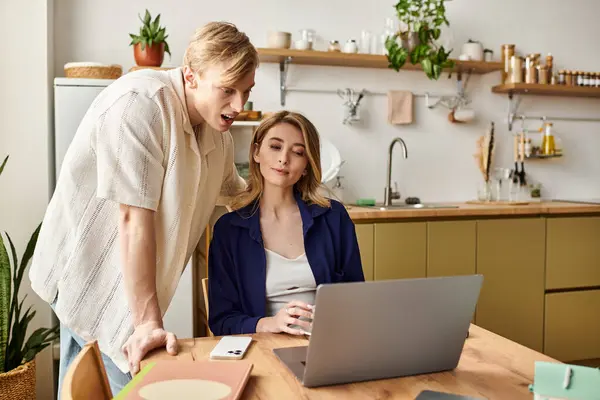 Charming pair cozies up in their stylish kitchen, discovering new ideas on a laptop. — Stock Photo