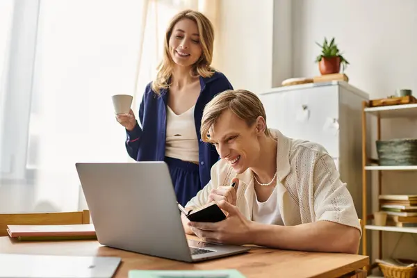 Couple shares joy and laughter while working on a creative project at home in a stylish setting. — Stock Photo