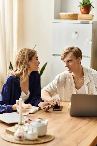 A loving couple shares a warm moment in their stylish home, blending work and romance. — Stock Photo