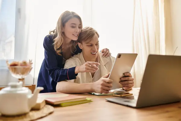 A loving couple shares a joyful moment at home, engaged in a fun activity with technology. — Stock Photo