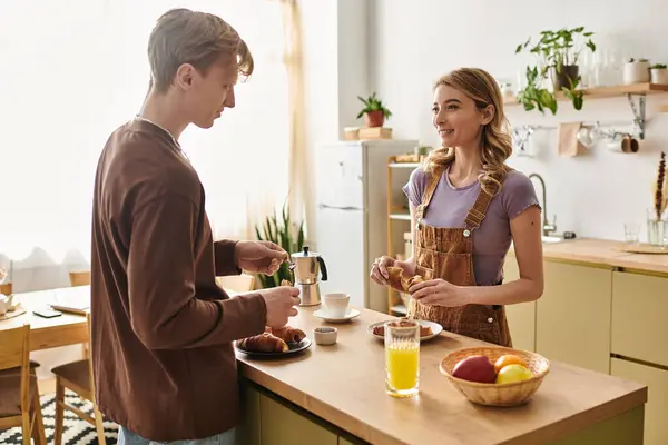 Nella loro cucina moderna, una coppia gode di una calda mattina, condividendo la colazione con sorrisi. — Foto stock