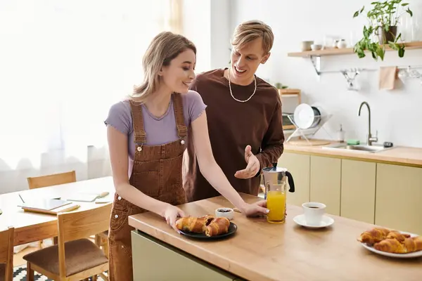 A loving couple shares a warm and playful morning in their inviting kitchen, preparing breakfast. — Stock Photo