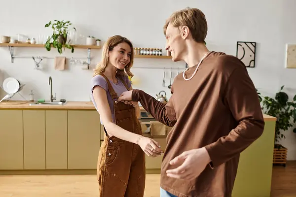 A loving young couple enjoys playful moments together in their modern kitchen, radiating happiness. — Stock Photo