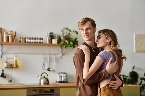 A happy young couple embraces in their cozy kitchen, radiating love and affection for each other. — Stock Photo
