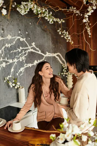 Pareja animada disfruta de una cálida conversación, la planificación de su próxima boda en medio de la decoración floral. - foto de stock
