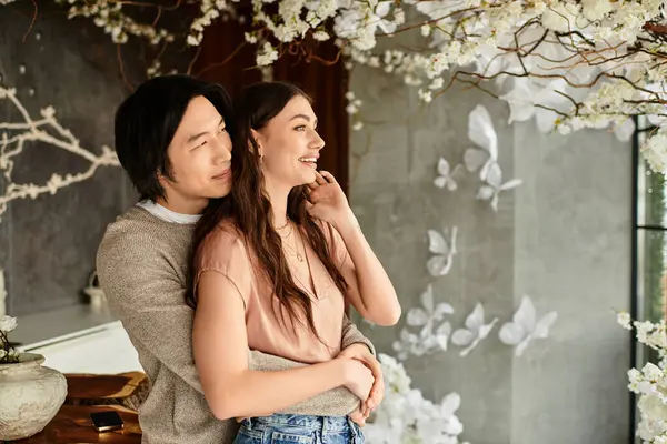 Una coppia vivace gode di un abbraccio amorevole in uno spazio splendidamente decorato pieno di fiori. — Foto stock