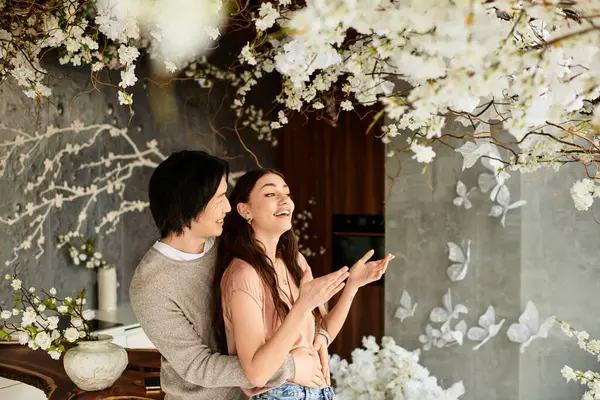 Loving couple enjoys precious moments while getting ready for their wedding surrounded by blooms. — Stock Photo