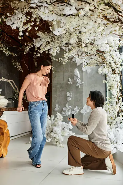 In a beautiful garden, a man kneels to propose to his partner, enveloped in love. — Stock Photo