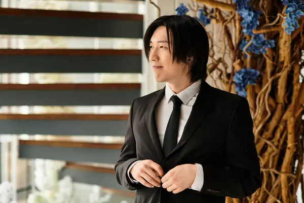 Handsome groom stands confidently, adjusting his attire for the big wedding moment. — Stock Photo