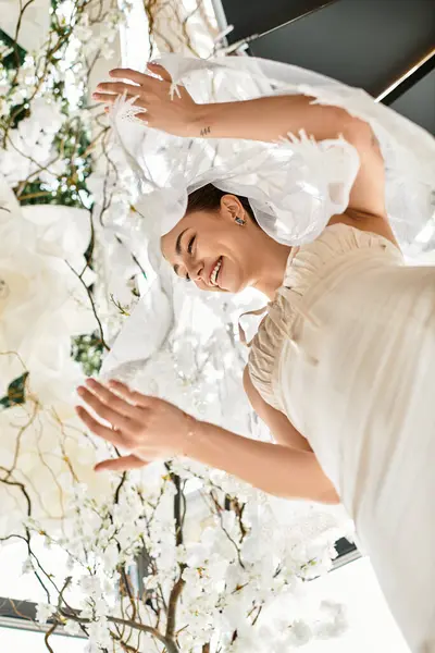 Una novia radiante viga de alegría bajo una elegante decoración floral en su hermosa boda. - foto de stock