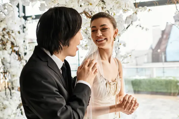 A loving couple gazes into each others eyes, surrounded by blossoms and sharing moments of joy. — Stock Photo