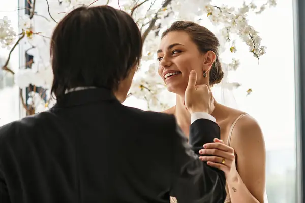 A young couple joyfully enjoys their wedding day, surrounded by beautiful white flowers and love. — Stock Photo