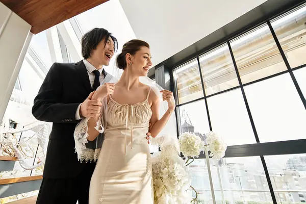 Coppia condivide sorrisi affettuosi mentre celebra il loro giorno del matrimonio in una splendida sede. — Foto stock
