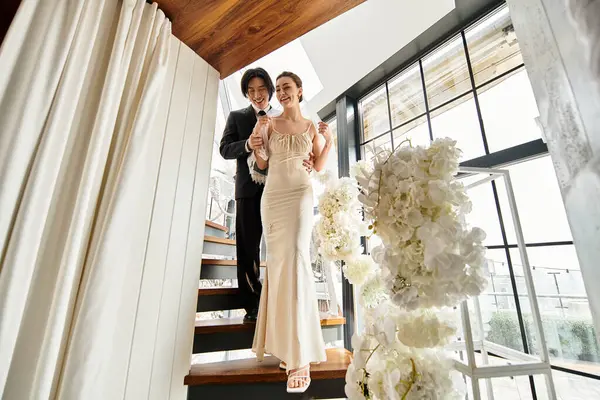 A loving couple joyfully ascends the staircase, basking in their wedding days warmth. — Stock Photo