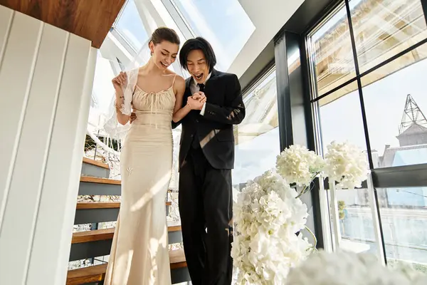Couple radiates happiness as they walk hand in hand down the staircase, celebrating love and unity. — Stock Photo