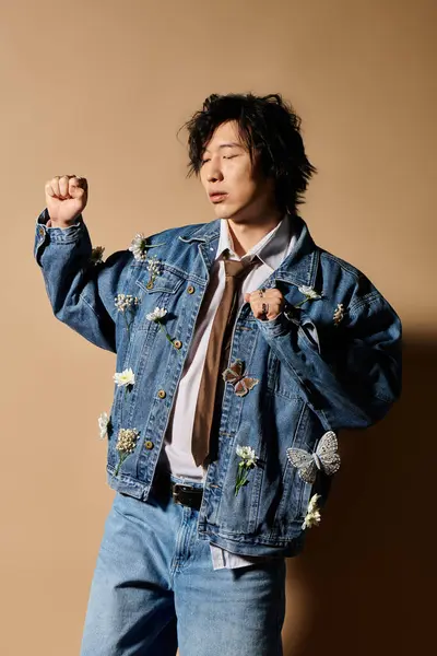 Asian man models trendy spring attire with floral embellishments in a creative studio setting. — Stock Photo