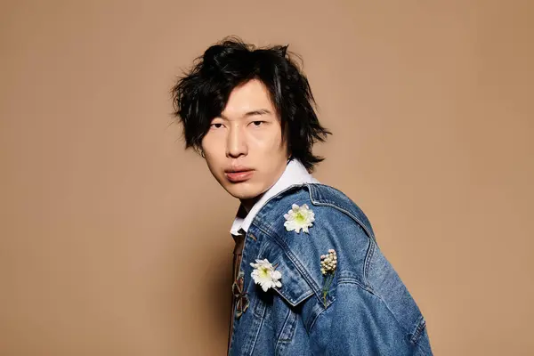 A fashionable Asian man showcases spring trends in a chic studio setting with an artistic flair. — Stock Photo