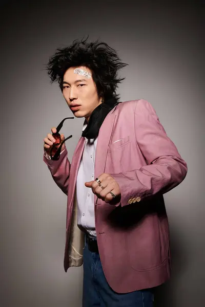 A fashionable asian man poses confidently in a stylish outfit with unique flair in springtime. — Stock Photo
