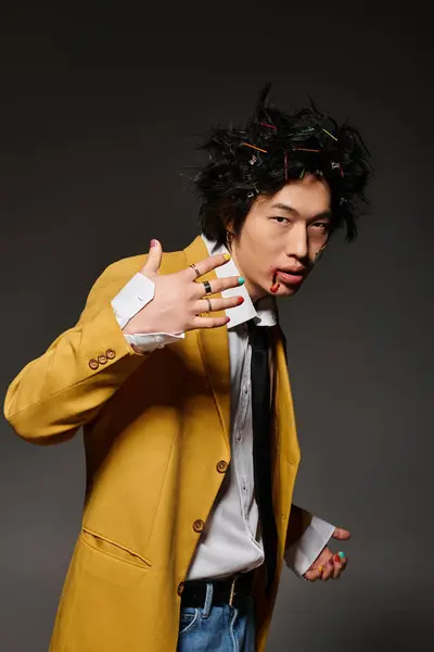 Asian man with blood on face dons vibrant clothing while exuding confidence in a trendy studio atmosphere. — Stock Photo