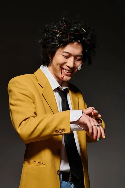 A fashionable Asian man with blood on face in trendy attire enjoys a playful moment in a stylish studio. — Stock Photo