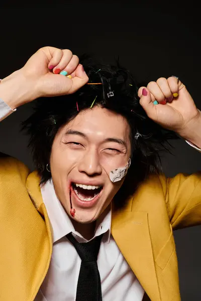 A confident Asian man with blood on face screaming while having fun in a studio. — Stock Photo