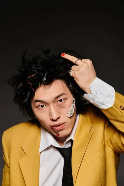 Fashionable Asian man with blood on face showing middle finger in spring attire with a striking hairstyle. — Stock Photo