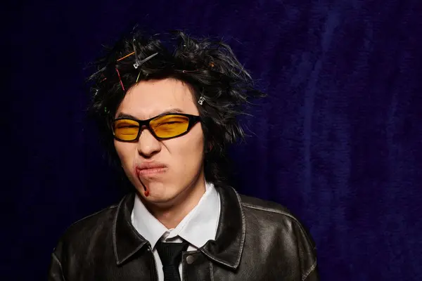 A displeased Asian man with blood on face showcases unique spring fashion trends in stylish studio attire. — Stock Photo
