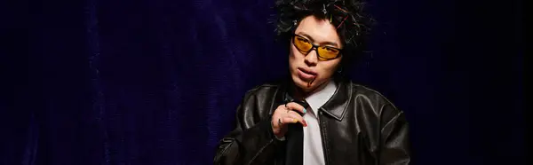 Un hombre asiático con sangre en la cara vestido con atuendo de moda de primavera presenta su sentido distintivo de la moda en un estudio, pancarta - foto de stock