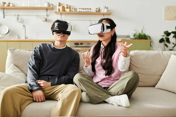A joyful young couple engages in an immersive virtual reality experience on their couch. — Stock Photo