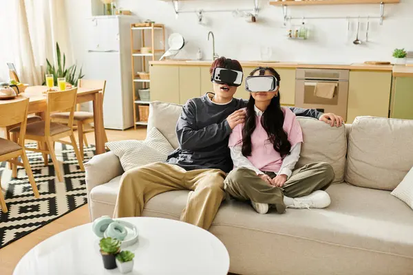Una giovane coppia asiatica condivide un momento divertente nella loro casa, immersa nella realtà virtuale. — Foto stock
