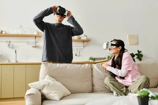 Una giovane coppia gode di una realtà virtuale immersiva insieme a casa, condividendo momenti speciali. — Stock Photo