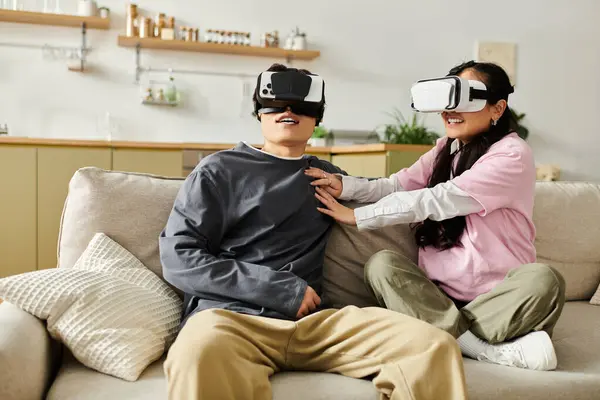 Young couple shares a fun moment while playing virtual reality games at home, filled with laughter. — Stock Photo