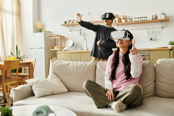 Um jovem casal se envolve em uma divertida sessão de jogos de realidade virtual em sua casa acolhedora enquanto relaxado. — Fotografia de Stock