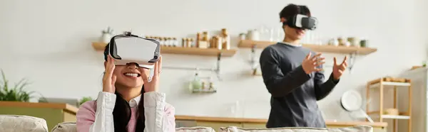 A happy couple enjoys virtual reality together at home in their stylish living room, banner — Stock Photo