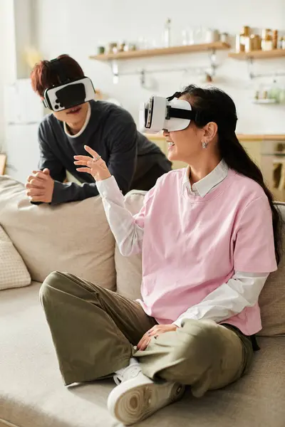 Young couple shares a fun moment exploring virtual reality in their stylish living room. — Stock Photo