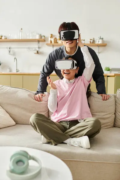 Una giovane coppia si gode la realtà virtuale a casa, condividendo risate e gioia insieme. — Stock Photo