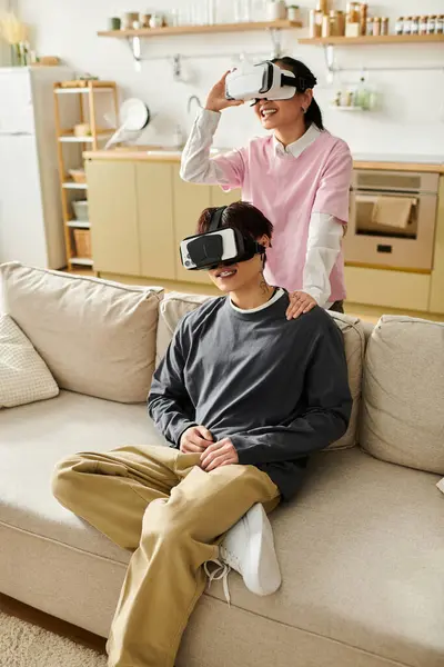 Couple immersed in virtual reality experiences at home, sharing laughter and joy together. — Stock Photo