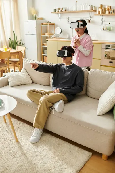Giovani coppie condividono risate ed emozioni mentre esplorano mondi virtuali nella loro accogliente casa. — Stock Photo