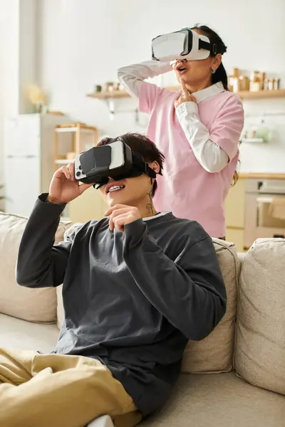 Young couple immersed in virtual reality while having fun at home, sharing joyful moments. — Stock Photo