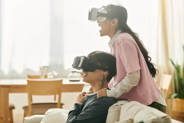 A young couple shares laughter while immersed in virtual reality, exploring new adventures. — Stock Photo